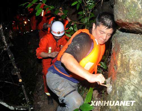 一名網(wǎng)名叫“煙花”的游客（右一）在救援人員的幫助下走出峽谷。新華社發(fā)（李進發(fā)攝）