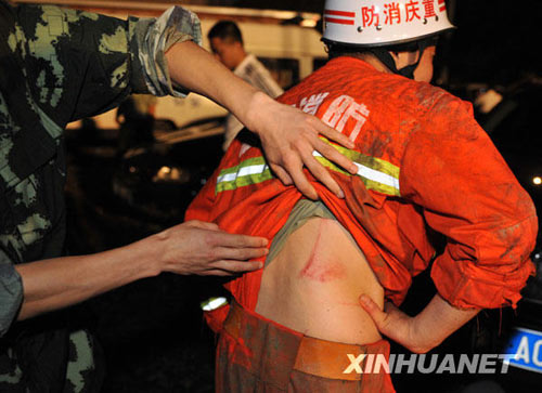 搜救人員在察看戰(zhàn)友被山石劃破的傷口。新華社發(fā)（李進發(fā)攝）