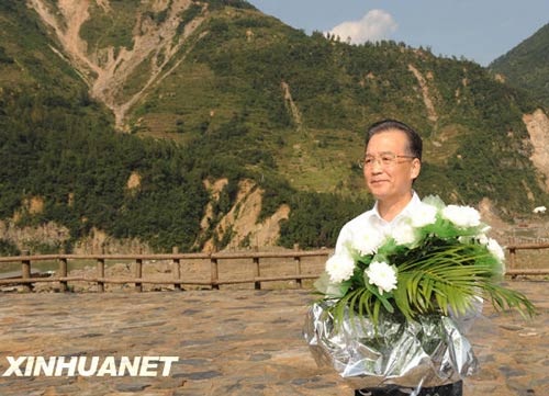 溫家寶總理十分關(guān)注災(zāi)后重建進(jìn)展情況。在國(guó)慶節(jié)和中秋佳節(jié)即將來(lái)臨之際，他第8次踏上了一直牽掛的這塊土地。在9月24日至26日的三天時(shí)間里，他奔波穿行于地震重災(zāi)區(qū)的城鄉(xiāng)間，為節(jié)省時(shí)間，吃飯盡量安排在火車上；連續(xù)兩個(gè)晚上主持召開(kāi)會(huì)議，就災(zāi)后恢復(fù)重建的一系列重大問(wèn)題進(jìn)行研究部署。這是9月24日，溫家寶在青川縣紅光鄉(xiāng)東河口村地震遺址祭奠臺(tái)獻(xiàn)花。新華社記者黃敬文攝