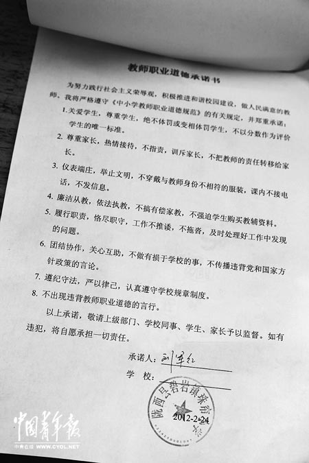 劉軍紅簽字的教師職業(yè)道德承諾書。本報記者 張鵬攝
