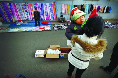 年輕母親為救3歲腦癱兒來青 寒風中抱兒擺攤賣棗