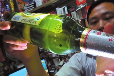 這瓶未開封的燕京啤酒內(nèi)有一顆黑色懸浮物。京華時報記者 徐曉帆 攝